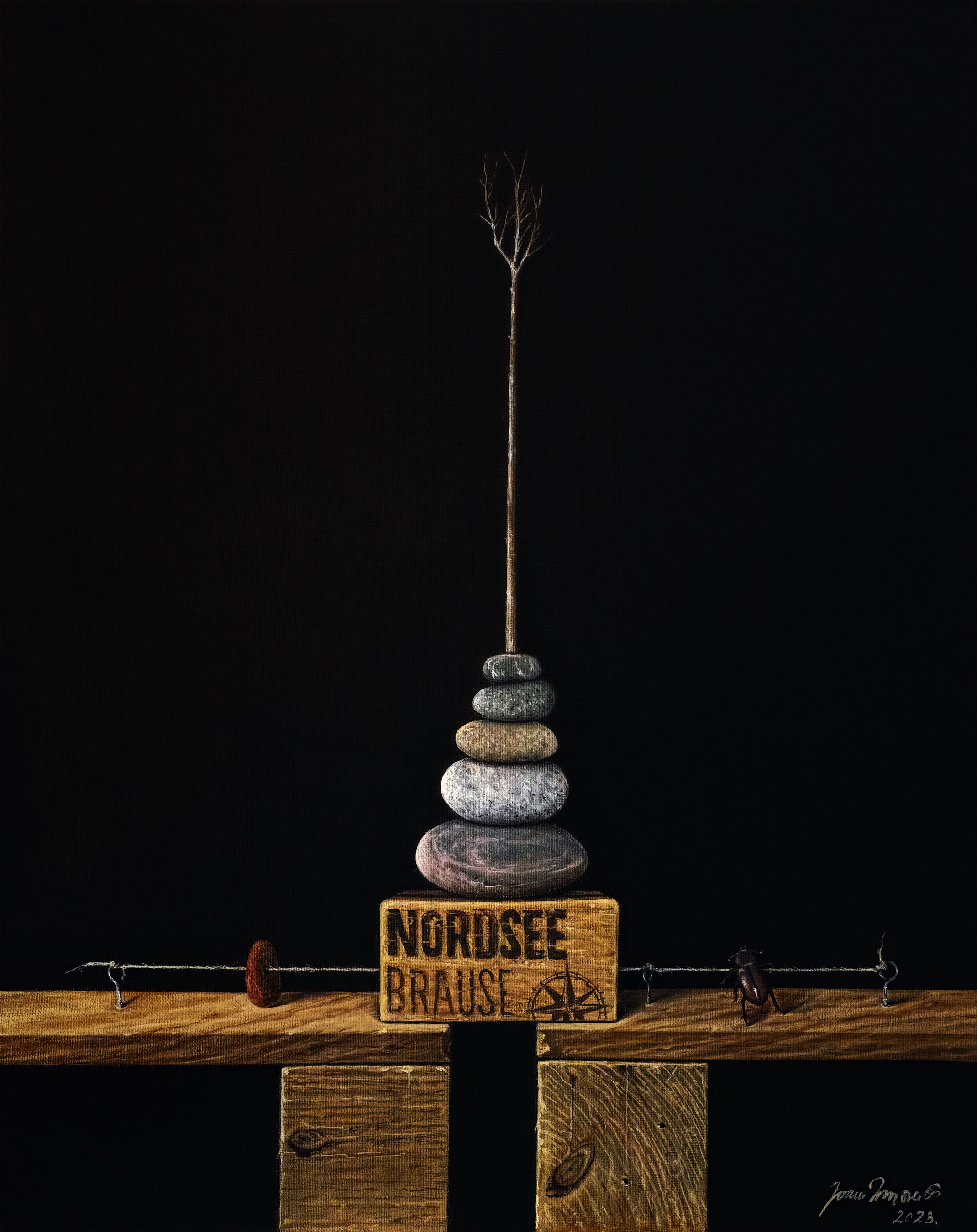 Ein Stapel aus sieben Steinen auf einem Holzblock mit der Aufschrift "Nordsee Brause", vor dunklem Hintergrund.